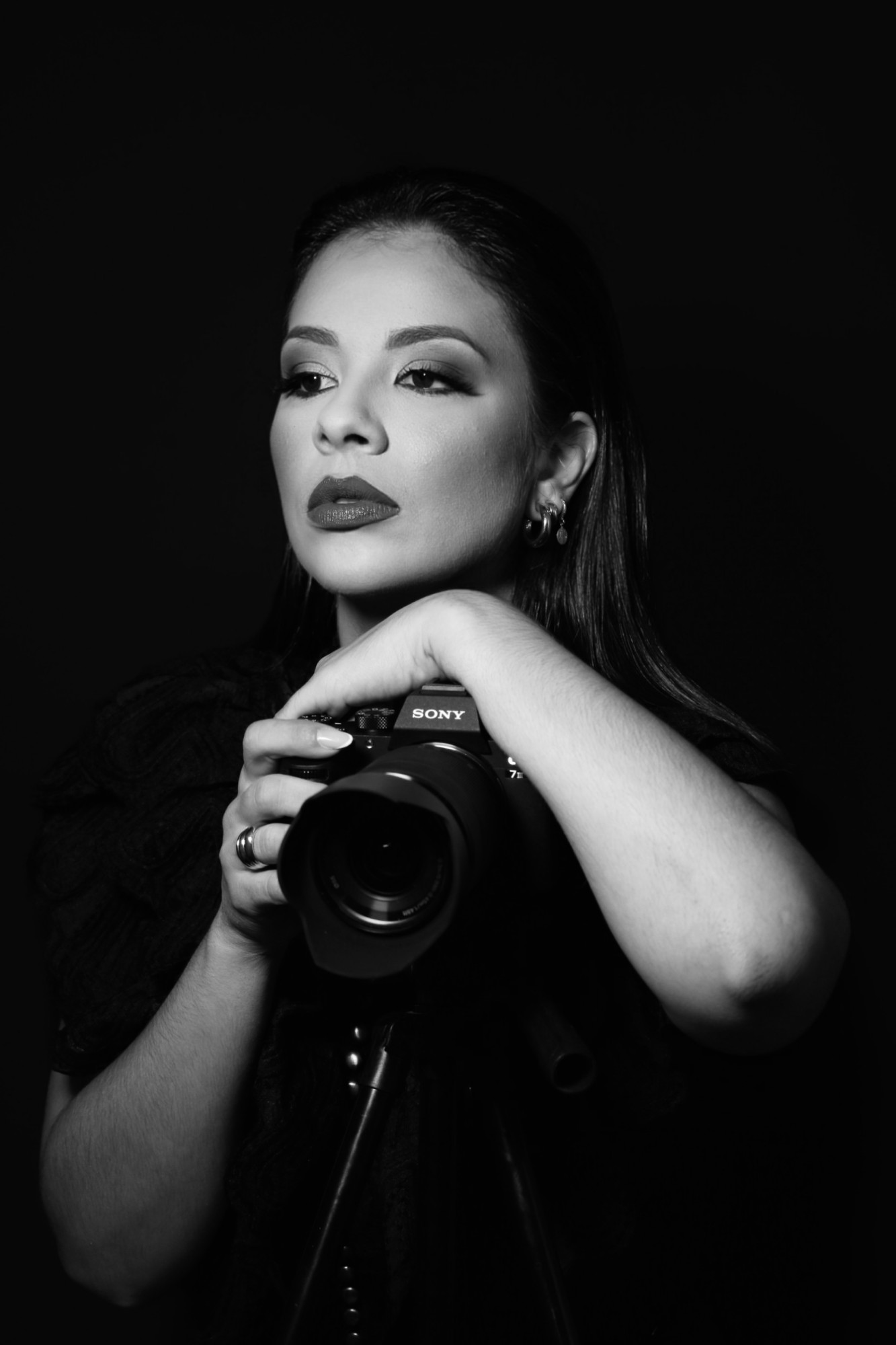 Jéssica Andrapa com uma câmera fotográfica, em preto e branco