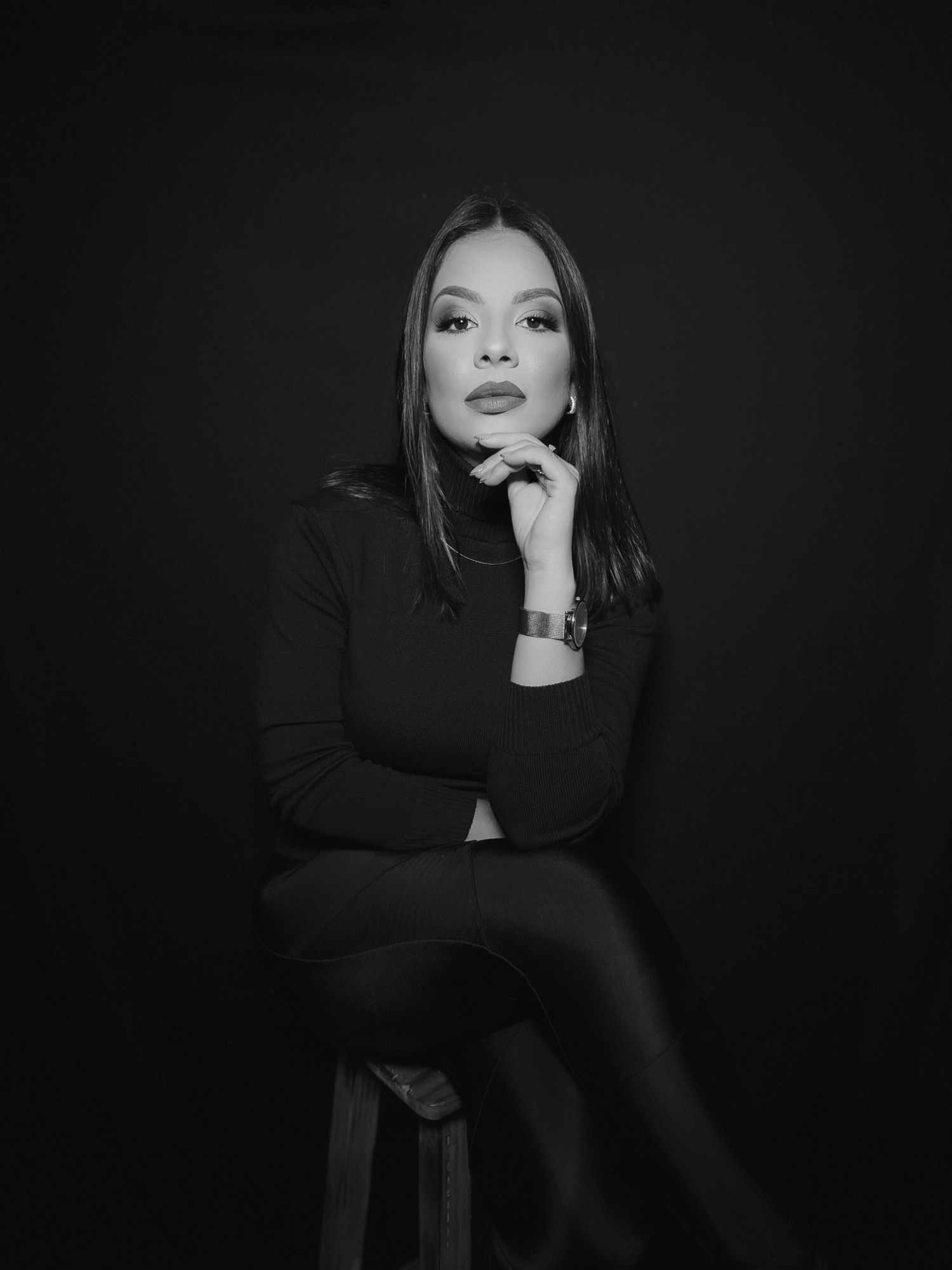 Jéssica Andrapa, CEO e Founder da Andrapa Soluções, sentada, com a mão no queixo, em preto e branco